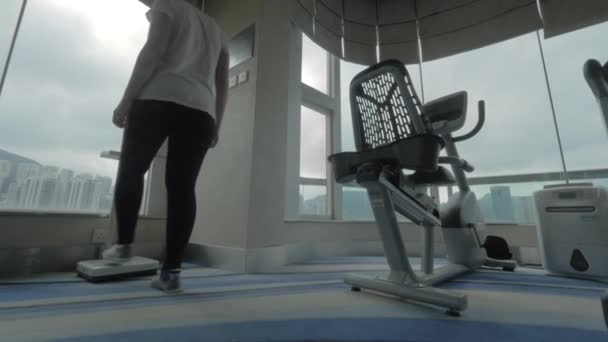 Woman weighing on scales in the gym — Stock video