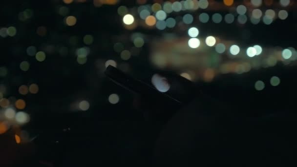 Woman with cellphone on city lights background at night — Αρχείο Βίντεο