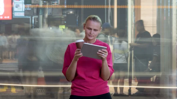 Vrouw met touchpad in drukke straat — Stockfoto