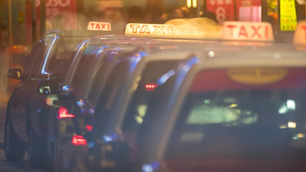 一行的出租车汽车在夜间的街道 — 图库照片