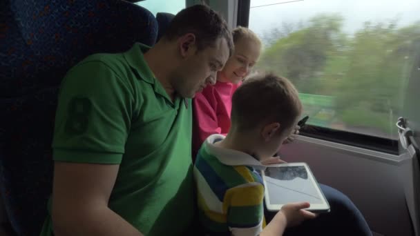 Семья путешествует на поезде и с помощью цифровых таблеток — стоковое видео