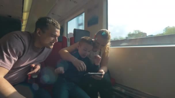 Ouders en kind reizen met de trein en het gebruik van mobiele telefoon — Stockvideo