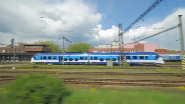 Vista desde el tren de pasajeros en las vías del ferrocarril y un tren que pasa . — Vídeos de Stock