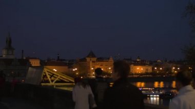 Gece Prag ve Charles Köprüsü'nde insanlar
