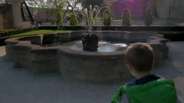 Közelről lassított nézet, a kisfiú a szökőkút futás és dobott érméket a vízbe, Prága, Cseh Köztársaság — Stock videók
