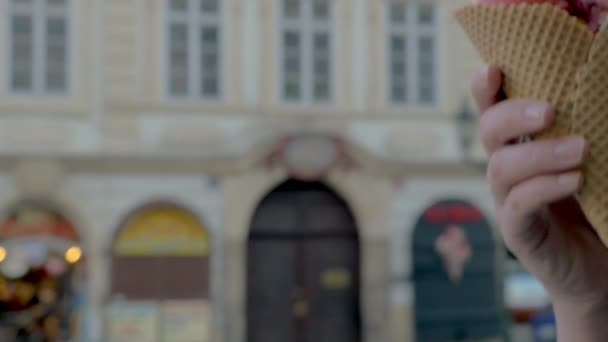 Zeitlupe Nahaufnahme einer Frau, die beginnt, Eiskugeln vor unfokussiertem Stadtbild im Hintergrund zu essen, Prag, Tschechische Republik — Stockvideo