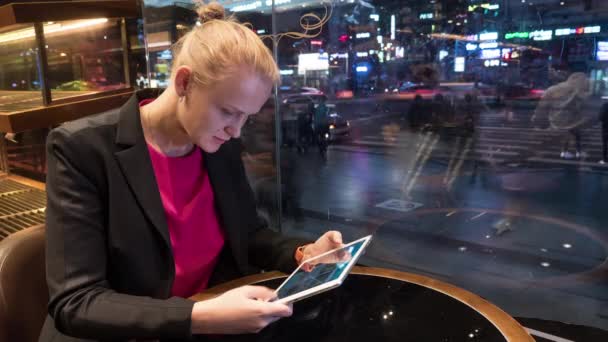 Femme utilisant pad dans café par fenêtre avec vue sur la ville — Video