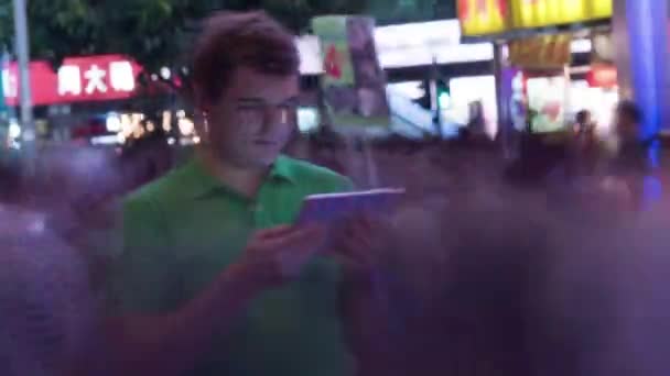 Timelapse of man with pad in crowded street at night — Stock Video