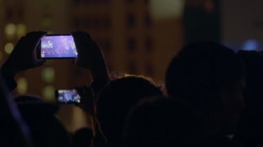 Seyirci adam zoom'u smartphone açık hava müzik konserinde sahne ve büyük ekran ile video kayıt