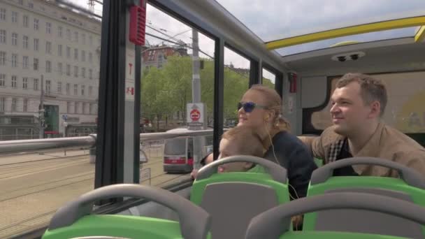 Family of three traveling in city by double-decker bus