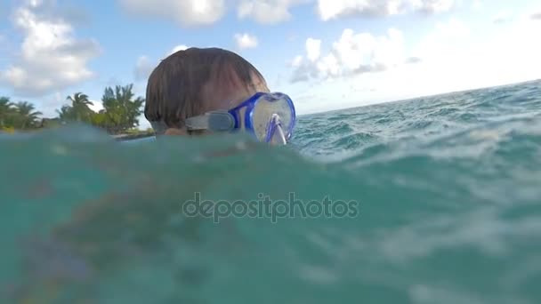 Kind mit Kamera im wasserdichten Etui beim Baden im Meer — Stockvideo