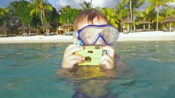 Gyermek fürdés óceánban és bevétel fénykép vízálló kamera — Stock videók