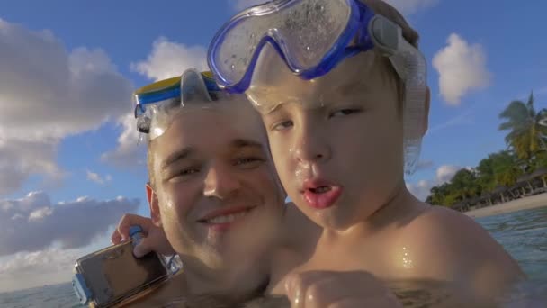 Widzenia w zwolnionym tempie szczęśliwy młody ojciec z synem w wodzie w maskach snorkeling, Port Louis, Mauritius wyspa — Wideo stockowe