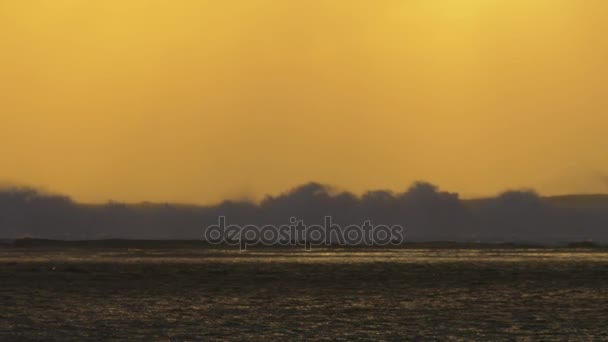 Vue au ralenti des vagues de l'océan contre le coucher du soleil jaune rouge, île Maurice 