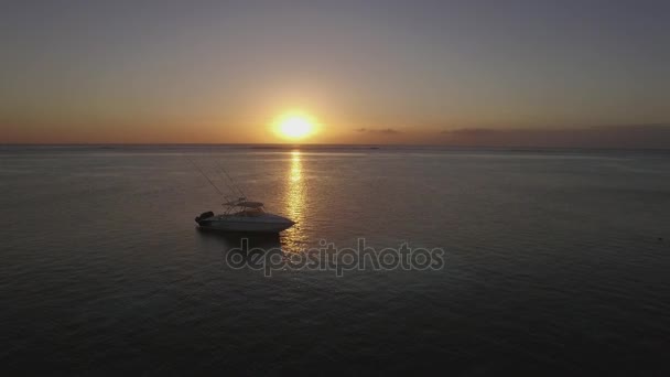 Flygande över båten i havet vid solnedgången — Stockvideo