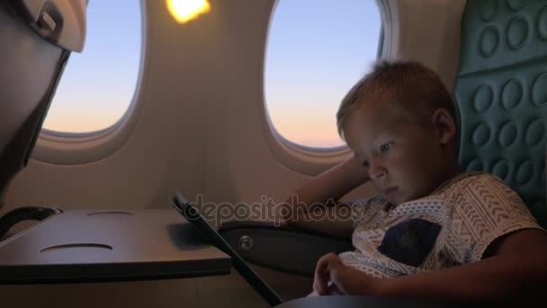 Скучный ребенок с блокнотом в самолете — стоковое видео