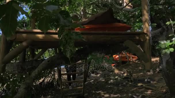 母と息子、木 々の間の木のデッキでリラックス — ストック動画
