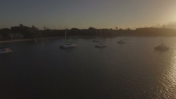 Vliegen over jachten langs de kust bij zonsondergang — Stockvideo