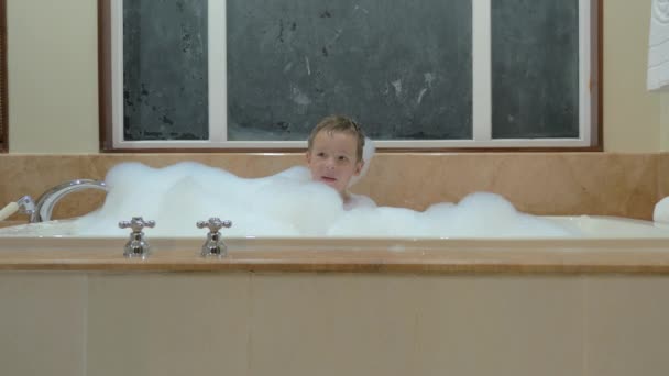 Παιχνιδιάρικο παιδί έχοντας μπάνιο με αφρό — Αρχείο Βίντεο