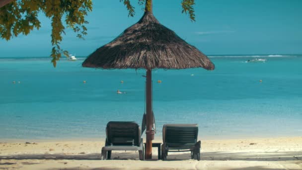 Costa del océano con chaise longues y sombrilla — Vídeos de Stock