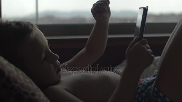 Kind nutzt digitales Tablet im Bett — Stockvideo