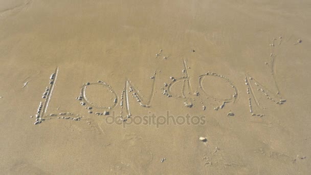 Onda do mar lavando Londres escrito na areia — Vídeo de Stock
