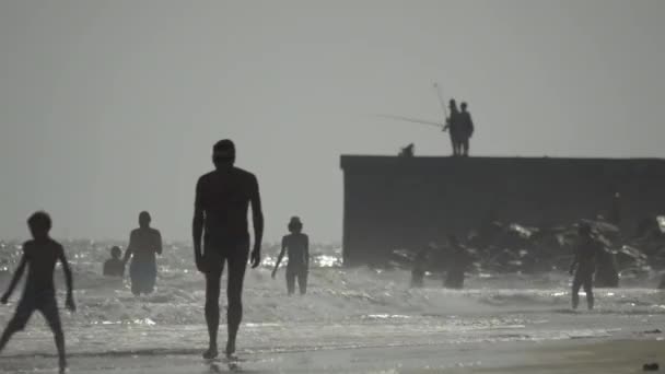 Personas descansando en la orilla del mar — Vídeos de Stock