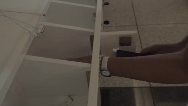 Женщина оставляет телефон в шкафчике для зарядки — стоковое видео