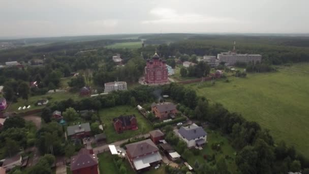 Vliegen op Lukino dorp met kathedraal van ascensie — Stockvideo