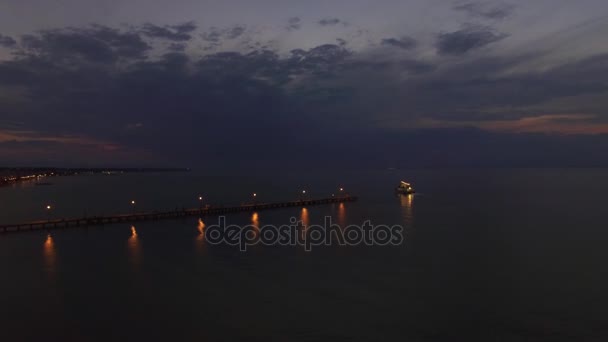 Fliegen über Meer, Pier und Segelboot bei Nacht — Stockvideo