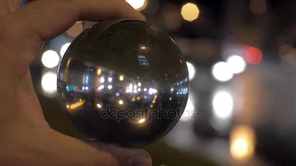 En regardant la ville de nuit à travers la boule de verre — Video