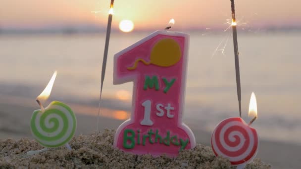 Baby meisje eerste verjaardag kaars op het strand — Stockvideo