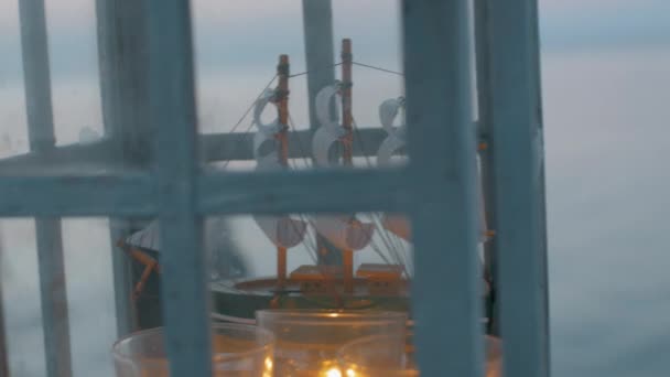 Открытый фонарь с моделью корабля и свечами — стоковое видео