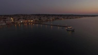 Gece denizde turistik tekne üzerinde uçan