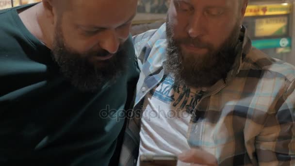 Visão de perto de dois homens brancos maduros barbudos usando o smartphone juntos — Vídeo de Stock