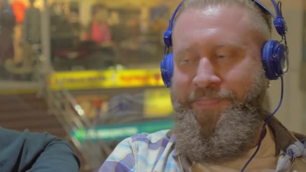 Twee mannen, luisteren naar muziek in winkelcentrum — Stockvideo
