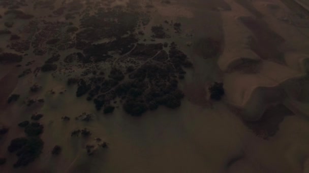 Воздушный пейзаж с песчаными дюнами на побережье на закате — стоковое видео