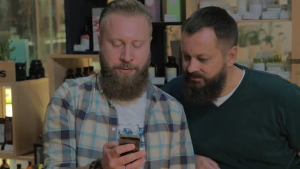 Dos hombres barbudos usando un teléfono inteligente — Vídeo de stock