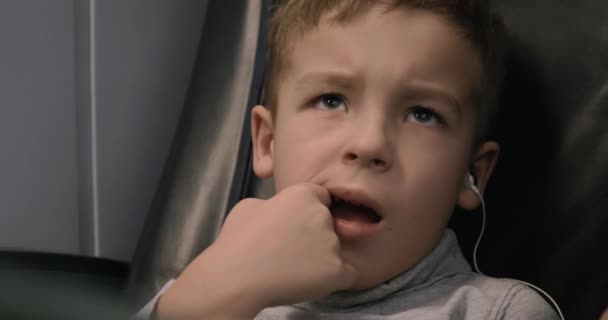 Junge mit Kopfhörern schaut im Zug fern — Stockvideo