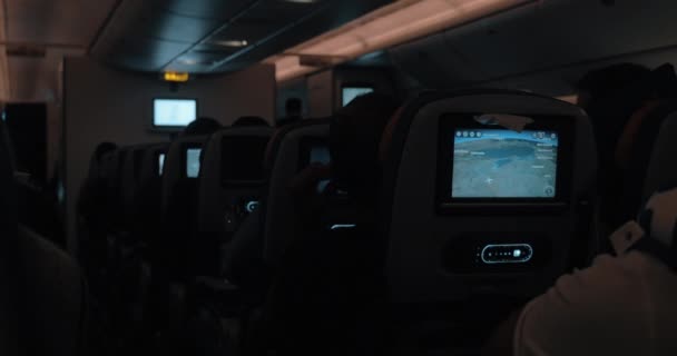 People traveling by blane at night. Dark cabin with working seat monitors — Stock Video