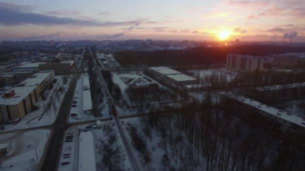 Aerial view of cargo train crossing winter city at sunrise. St. Petersburg — Stock Video