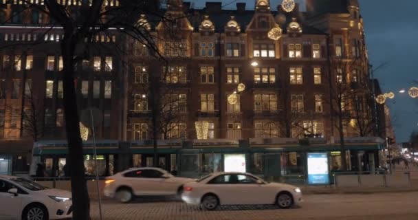 Ночная улица с автомобильным движением и рождественскими украшениями в Хельсинки, Финляндия — стоковое видео