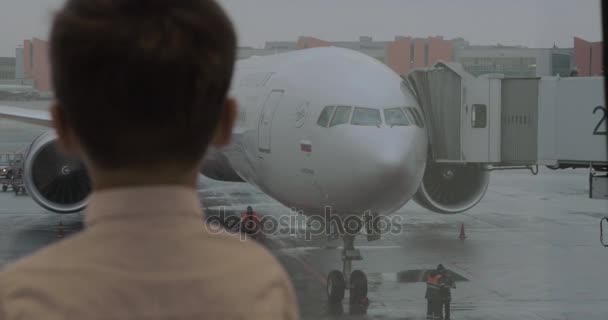 Kind betrachtet Flugzeug vor dem Boarding auf dem Moskauer Flughafen Scheremetjewo — Stockvideo