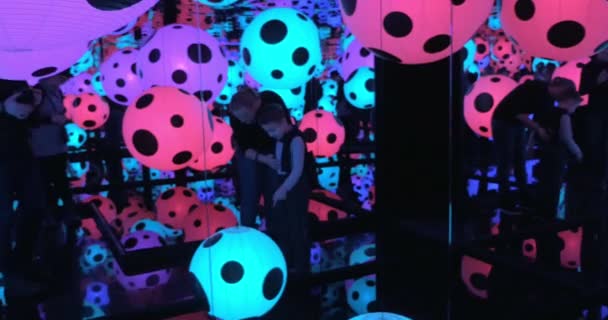 Bezoekers op Infinity gespiegeld kamer met kleurrijke verlichte ballen — Stockvideo