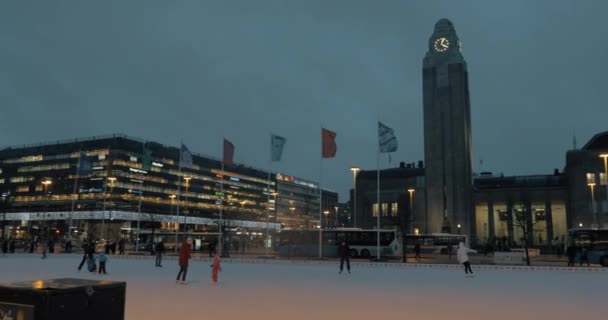 Personas en pista de patinaje cerca de la estación central de tren en Helsinki, Finlandia — Vídeo de stock