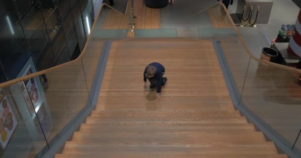 Дитина, отримавши задоволення від сходи в залі — стокове відео