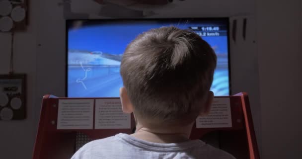 Niño jugando simulador de juego de carreras — Vídeos de Stock