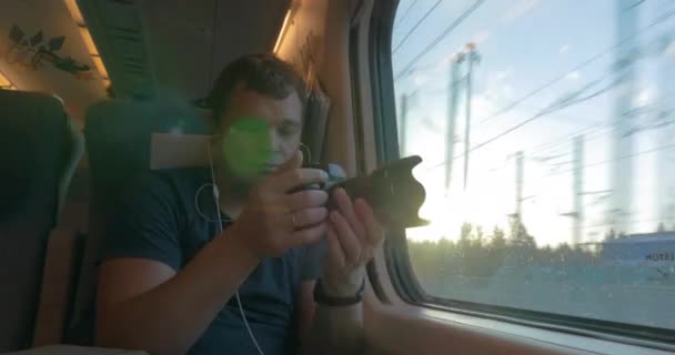 Un homme en train filme et regarde par la fenêtre — Video