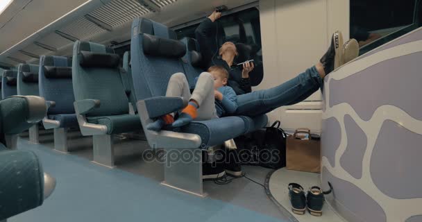 Mãe e filho passando o tempo com eletrônicos durante a viagem de trem — Vídeo de Stock