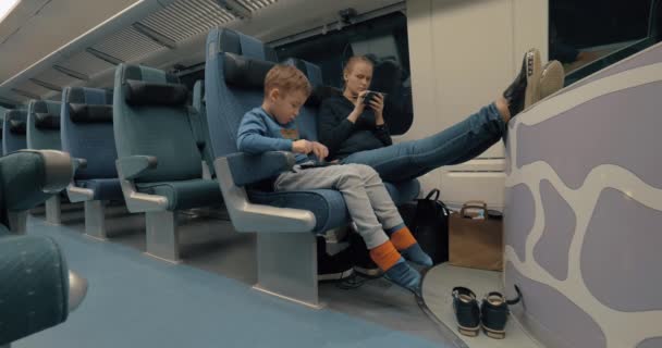 Madre e bambino utilizzando l'elettronica durante il viaggio in treno — Video Stock